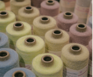 Pastel yarn cones on a shelf